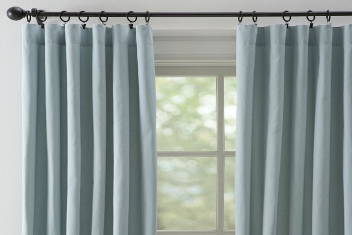 Light blue ring top drapes framing a window